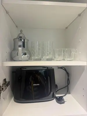 a tv sitting on a shelf with glasses on it at Studio luxe Centre ville in Casablanca