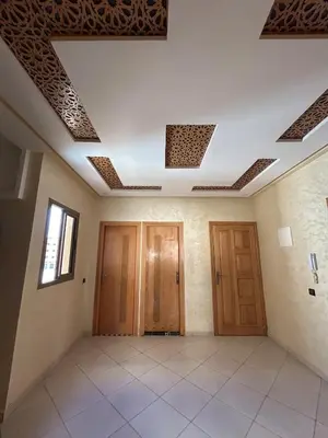 a room with two wooden doors and a ceiling at Skhirat apartment in Skhirat