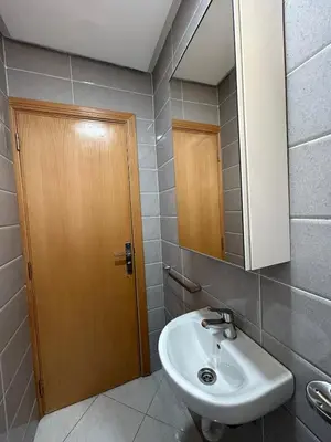 a bathroom with a sink and a wooden door at Skhirat apartment in Skhirat