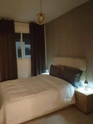 a bedroom with a large white bed and a window at Comfortable Escape Stylish Apartment Quiet Residence in Oulad Kerroum