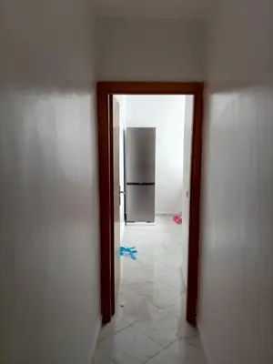 a hallway with a door to a kitchen with a refrigerator at Comfortable Escape Stylish Apartment Quiet Residence in Oulad Kerroum