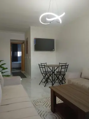 a living room with a couch and a table at Comfortable Escape Stylish Apartment Quiet Residence in Oulad Kerroum
