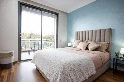 a bedroom with a large bed with a large window at Forest View -3 Bedroom Apartment - Near Airport in Nouaseur