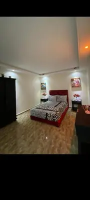 a bedroom with a bed and two tables in it at Appartement à louer in Rabat