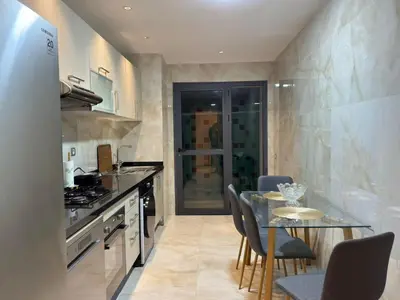 a kitchen with a table and chairs and a counter top at Furnished and bright apartment in Rabat