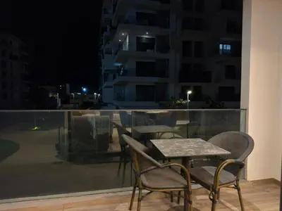 a table and chairs on a balcony at night at Furnished and bright apartment in Rabat