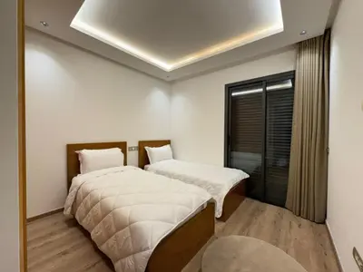 two beds in a room with white walls at Furnished and bright apartment in Rabat