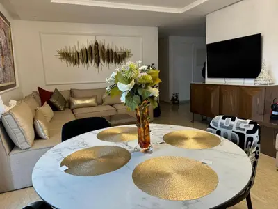 a living room with a table with a vase of flowers at Furnished and bright apartment in Rabat