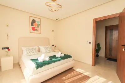 a bedroom with a white bed with a green blanket at New and bright stylish studio in Casablanca