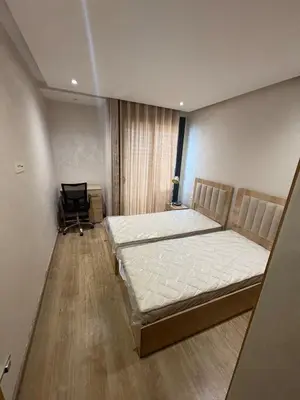 a bedroom with a bed and a chair in it at Luxurious Apartment in Hay Riad in Rabat