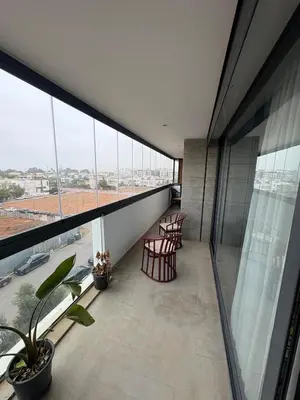 a balcony with chairs and windows in a building at Luxurious Apartment in Hay Riad in Rabat