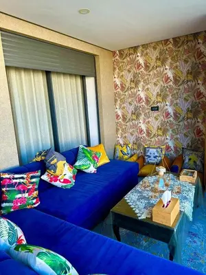 a living room with a blue couch and a table at Appartement meublé à louer à dar bouazza in Tamaris