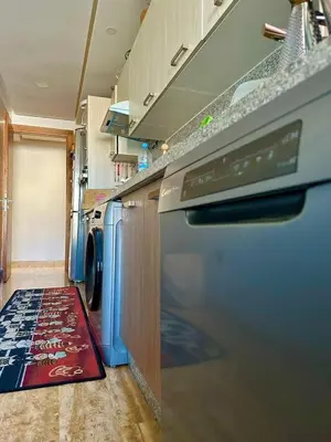a kitchen with a washing machine and a rug at luxury furnished apartment for rent in Tamaris