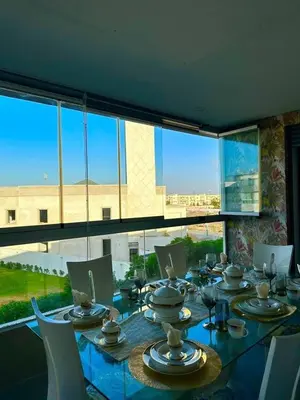 a dining room with a table and a large window at luxury furnished apartment for rent in Tamaris