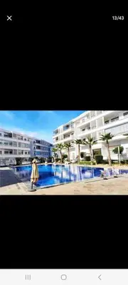 a person walking in front of a large apartment building at Apparemment in Mansouria
