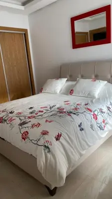 a bed with a blanket with flowers on it at Apparemment in Mansouria