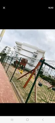 a fence in front of a white building at Apparemment in Mansouria