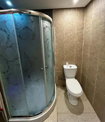 a bathroom with a toilet and a glass shower at Agdal Central Spacious 2BR with Terrace in Rabat