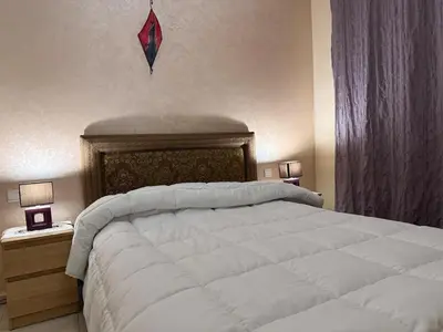a bedroom with a large white bed and two lamps at Agdal Central Spacious 2BR with Terrace in Rabat