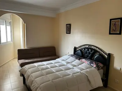 a bedroom with a bed and a couch at Agdal Central Spacious 2BR with Terrace in Rabat