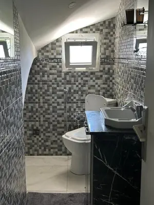 a bathroom with a toilet and a sink at Duplex océan harhoura avec une grande terrasse in Temara