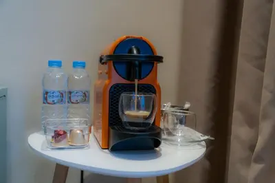 an orange mixer sitting on a table with bottles of water at AnfaSuites - Résidence Pashmina - Maarif - Parking in Maarif