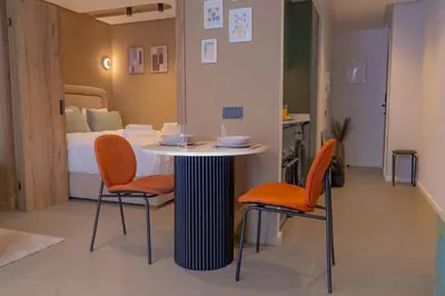 a room with a table and two chairs and a bed at AnfaSuites - Résidence Pashmina - Maarif - Parking in Maarif