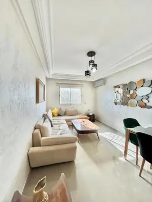 a living room with a couch and a table at Chic 2-bedroom apartment, pool and beach 5 min away in Mohammedia