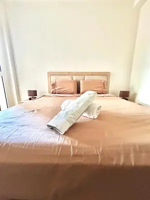 a bed with a pillow sitting on top of it at Chic 2-bedroom apartment, pool and beach 5 min away in Mohammedia