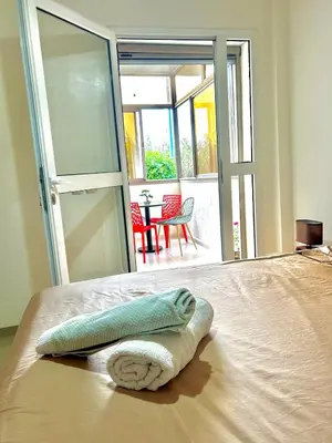 a towel on a bed in a room with an open door at Chic 2-bedroom apartment, pool and beach 5 min away in Mohammedia