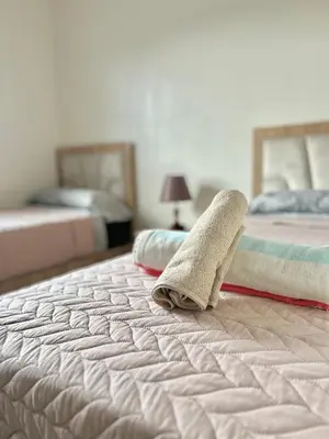 a bed with two beds with towels on it at Chic 2-bedroom apartment, pool and beach 5 min away in Mohammedia