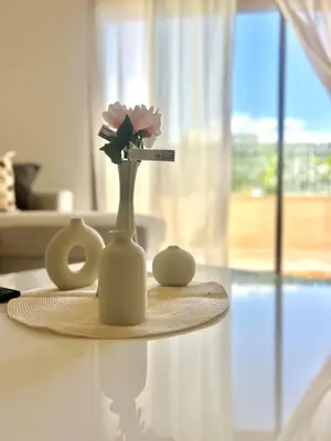 a white vase with flowers in it on a table at Zen Terrace Design Studio in Zenata, WiFi & Pool in Aïn Harrouda