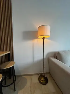 a lamp in a living room next to a couch at Zen Terrace Design Studio in Zenata, WiFi & Pool in Aïn Harrouda