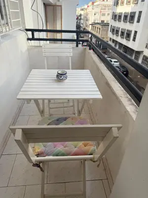 a white table on a balcony with a table on a ledge at Spacious apartment in Agdal, close to everything in Rabat