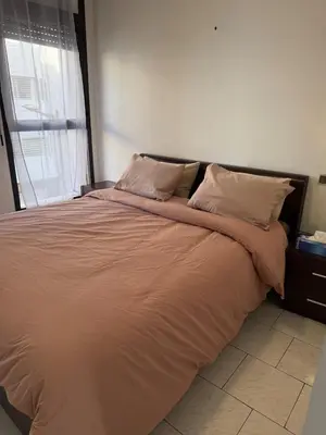 a large bed in a room with a window at Spacious apartment in Agdal, close to everything in Rabat