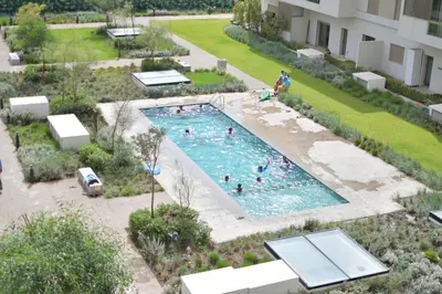 an overhead view of a swimming pool with people in it at Studio calme Vue piscine À deux pas de la mer in Aïn Sebaa