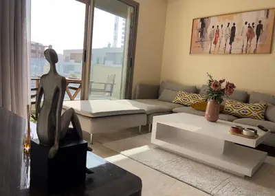 a living room with a couch and a table at Studio calme Vue piscine À deux pas de la mer in Aïn Sebaa