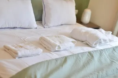 two towels are sitting on a white bed at Studio calme Vue piscine À deux pas de la mer in Aïn Sebaa