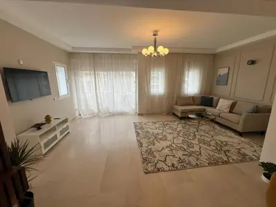 a large living room with a couch and a tv at Appartement 2 chambres in Casablanca