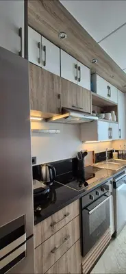a kitchen with wooden cabinets and a stainless steel refrigerator at Appartement Chic CFC - Anfasky in Casablanca