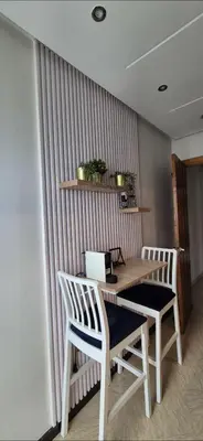 a wooden table with two chairs and a laptop on it at Appartement Chic CFC - Anfasky in Casablanca