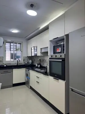 a kitchen with white cabinets and a stove top oven at Opposite Train Station & Tram Modern Quiet & Meals Available in Casablanca