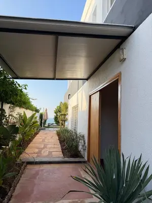 a walkway leading to a building with a door at Villa front mer in Rabat