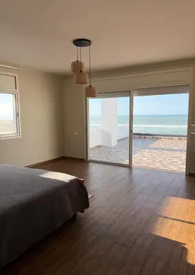 a bedroom with a bed and a view of the ocean at Villa front mer in Rabat