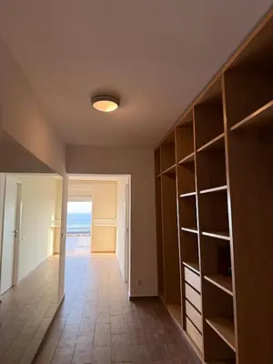 an empty room with a hallway with shelves and the ocean at Villa front mer in Rabat