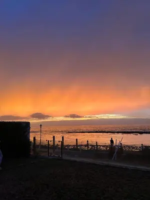 a person sitting on the beach at sunset at Villa front mer in Rabat