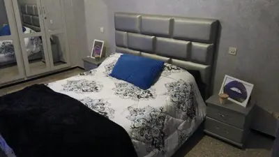 a bedroom with a large bed with a blue pillow at Appartement 5 pieces à casablanca in Casablanca