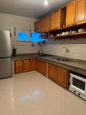 a kitchen with wooden cabinets and a stainless steel refrigerator at Comfortable apartment, Stade in Rabat