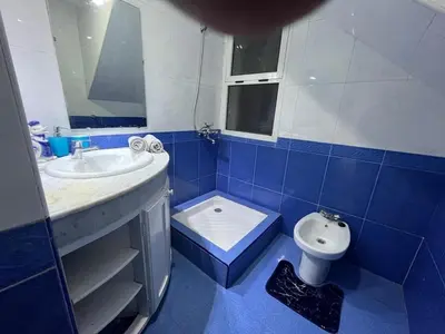 a blue and white bathroom with a sink and a toilet at Comfortable apartment, Stade in Rabat
