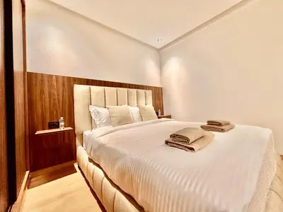 a bedroom with a large white bed with towels on it at Cozy & Central with Terrace, Parking and Fiber Wifi in Casablanca